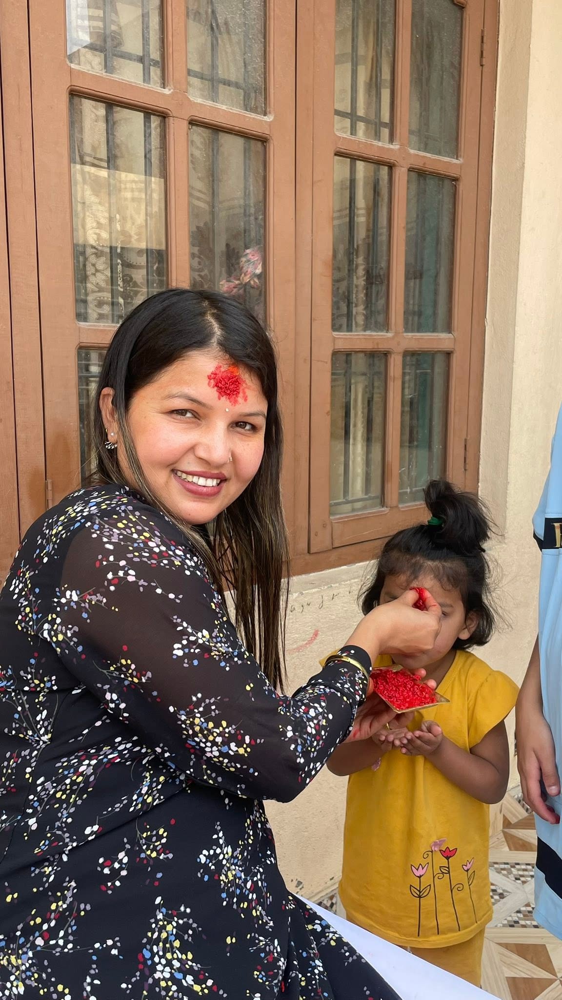 Caregiver giving tika to a little girl